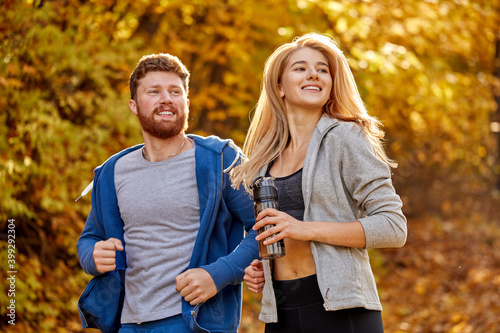 portrait of amazing couple training during fitness workout outdoors in the autumn forest. people living healthy active lifestyle on fresh air
