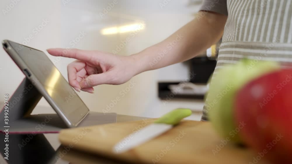 asian woman making smoothie juice with blender in modern kitchen at home. female using tablet searching recipe from internet via wifi connection. asian woman making smoothie juice with blender in modern kitchen at home. female using tablet searching recipe from internet via wifi connection.