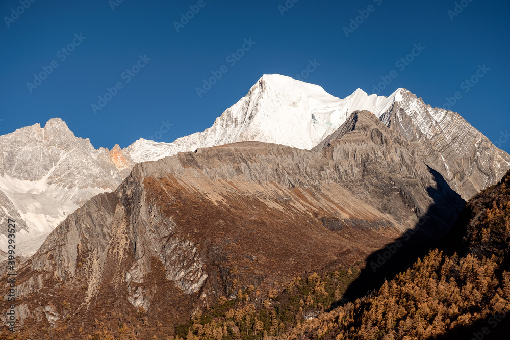 Holy mountain with sunlight and blue sky in Tibetan at Yading nature reserve