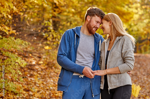 beautiful couple in the autumn nature, in love. portrait of bearded male and blonde female hugging, having romantic time in the forest