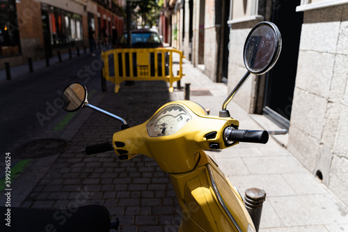 Yellow vintage moped bike on an old street of Madrid on sunny summer day