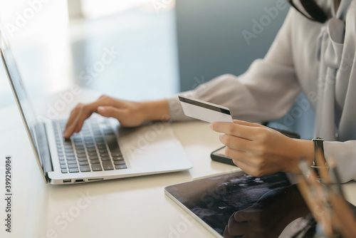 Closeup shot of an unidentifiable woman using her laptop at home to make online purchases with her credit card.