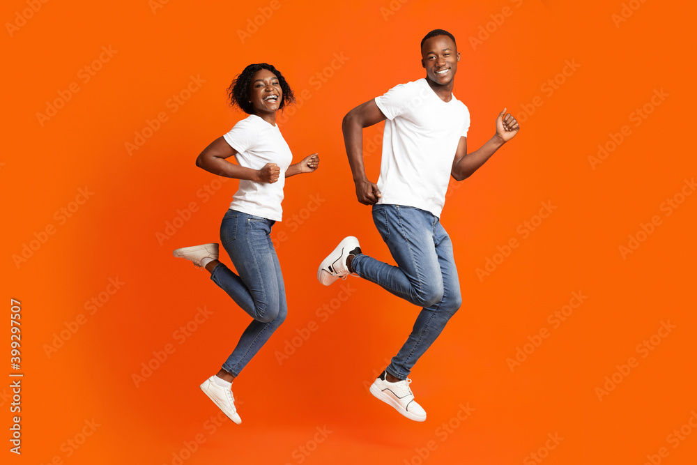 Loving african american couple running in the air, studio shot