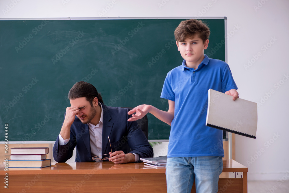 Young male teacher and schoolboy in the classroom Young male teacher and schoolboy in the classroom