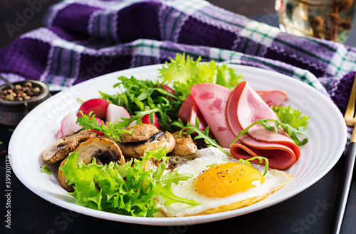 English breakfast - fried eggs, ham, fried mushrooms, radish and arugula. ketogenic, keto food.