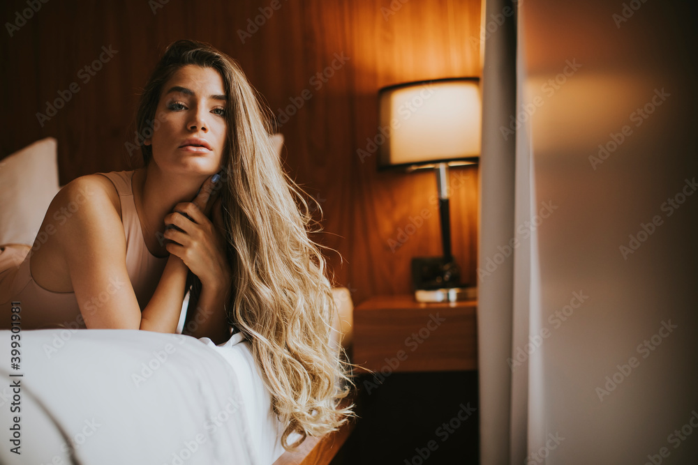 Beautiful young woman lying on a bed in the morning Beautiful young woman lying on a bed in the morning