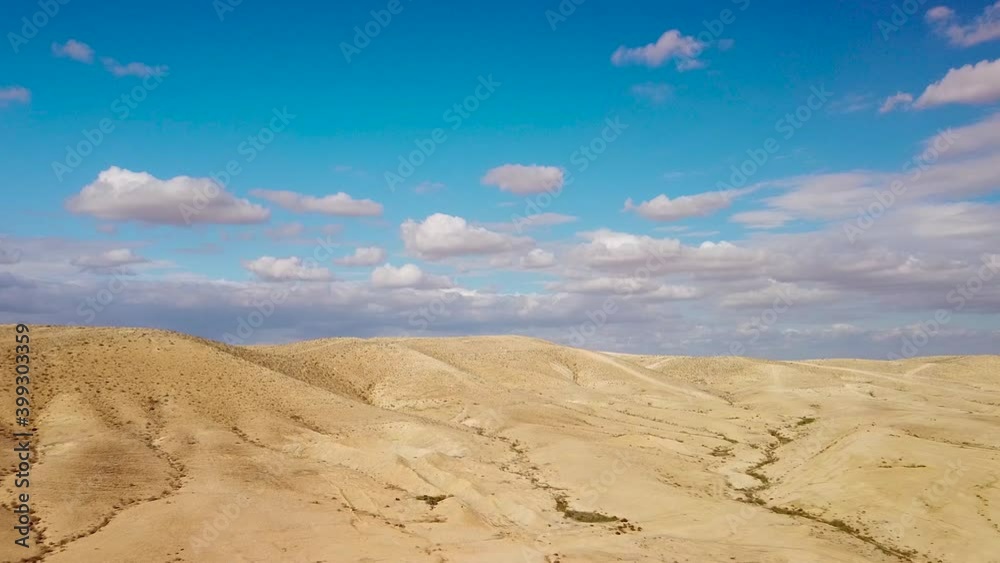 Backward flight over hills in desert Negev with fluffy clouds Backward flight over hills in desert Negev with fluffy clouds