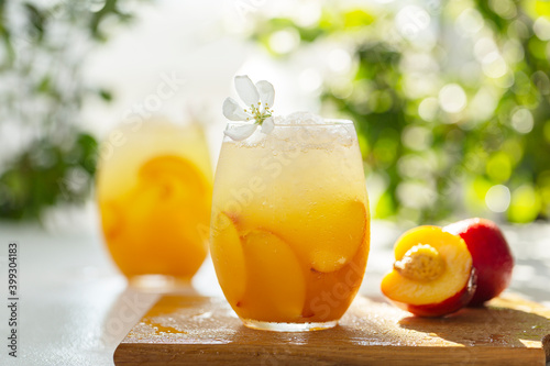 Peach cocktail or tea with ice. Refreshing iced tea with ripe peaches, selective focus.