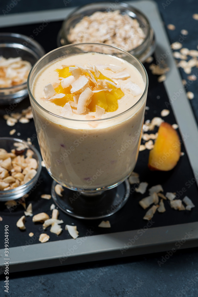 milkshakes with oatmeal and mango in glass, vertical milkshakes with oatmeal and mango in glass, vertical