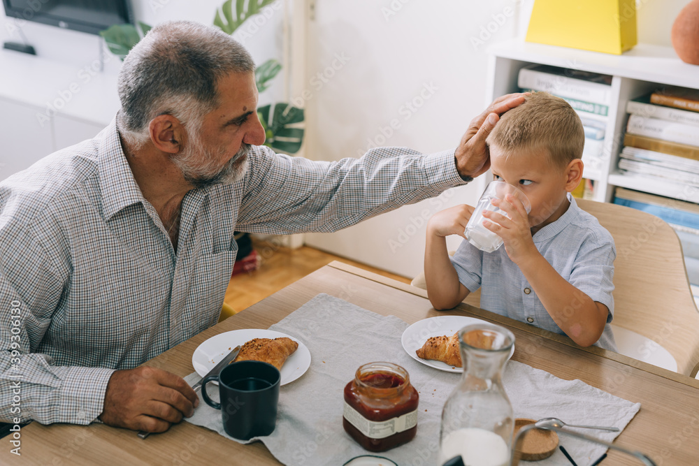 boy with his grandfather having breakfast at home boy with his grandfather having breakfast at home