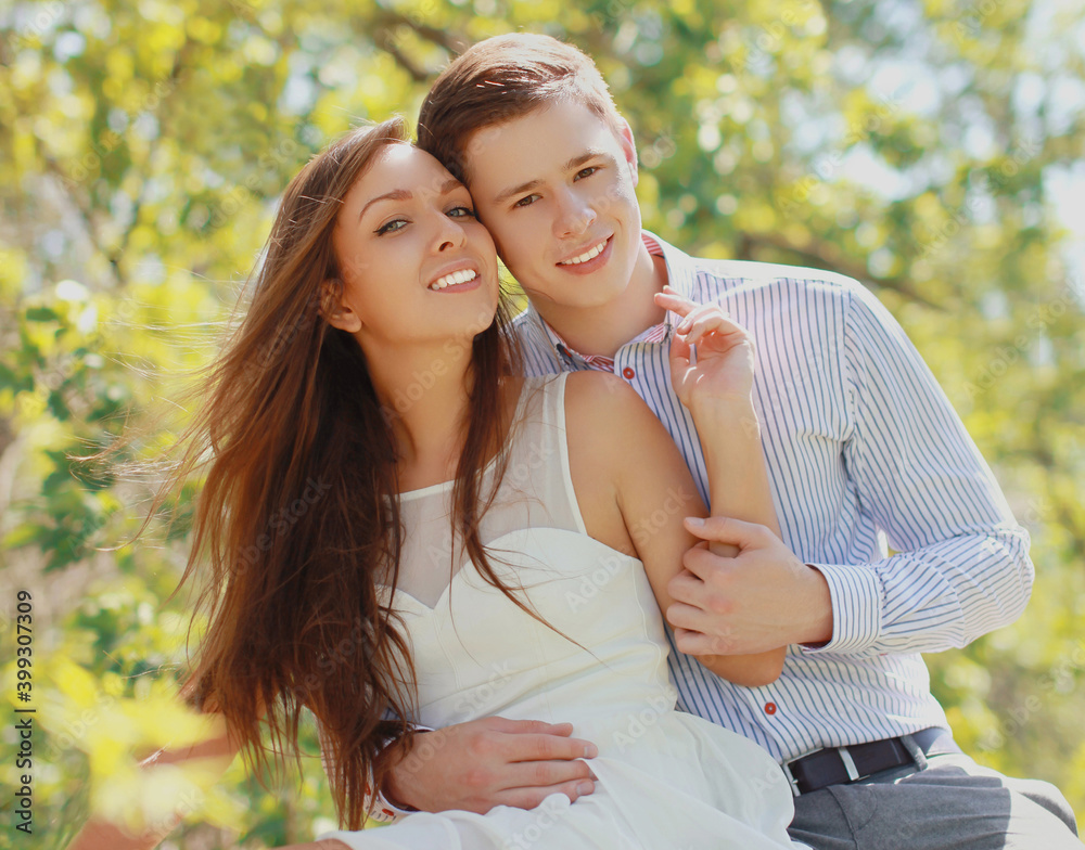 Naklejka premium Portrait of happy smiling young couple together outdoors in sunny park