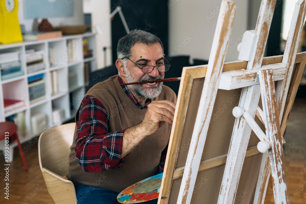senior man painting in his home