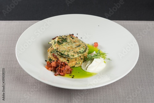Zucchini pancakes served with sun-dried tomatoes and cream cheese