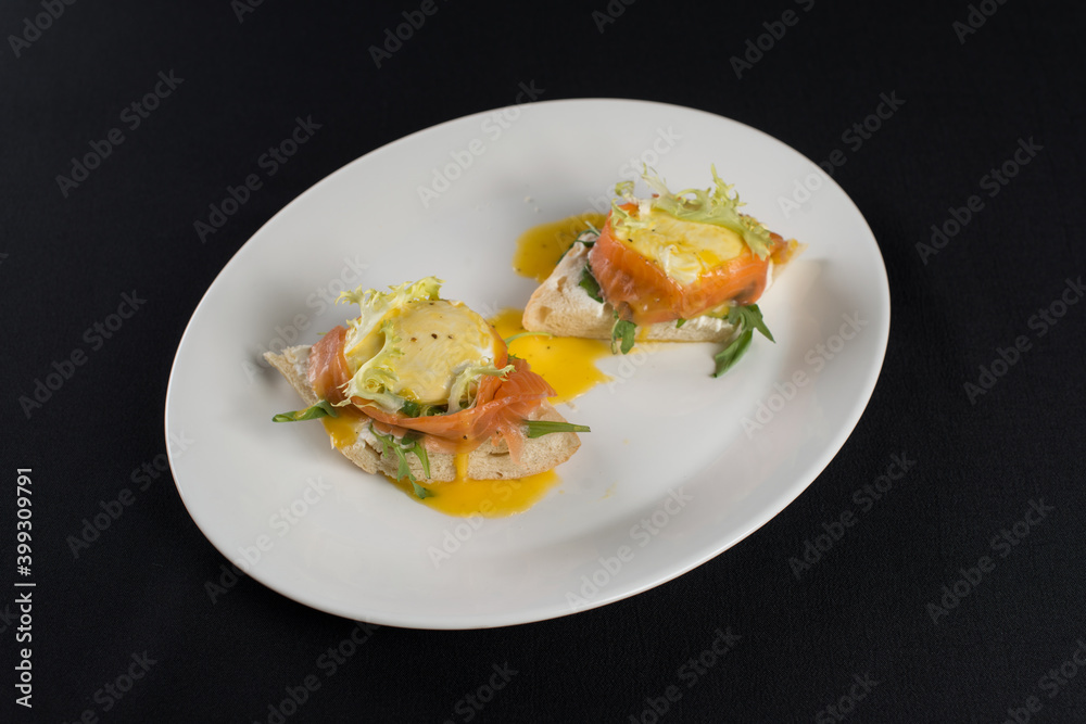 A delicious eggs benedict with lightly salted salmon and sauce. A delicious eggs benedict with lightly salted salmon and sauce.