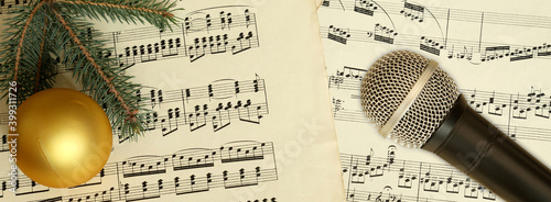 Christmas decoration. Microphone and fir branch on the background of music notes photo