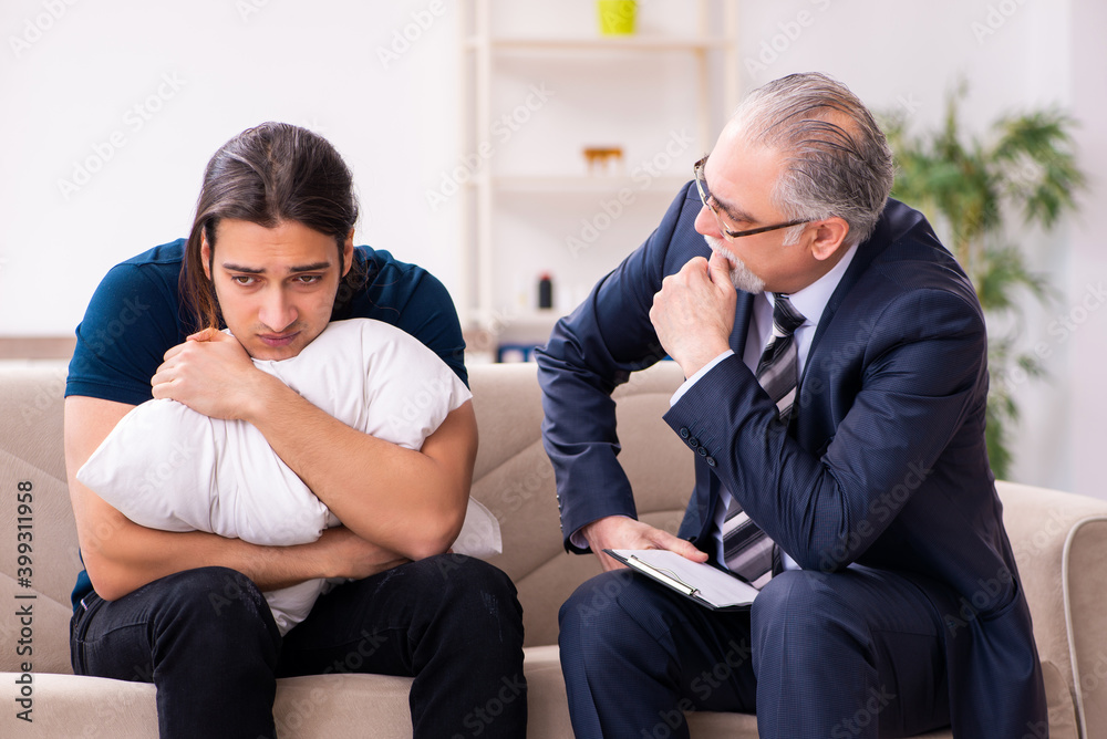 Young man visiting old male psychologist Young man visiting old male psychologist