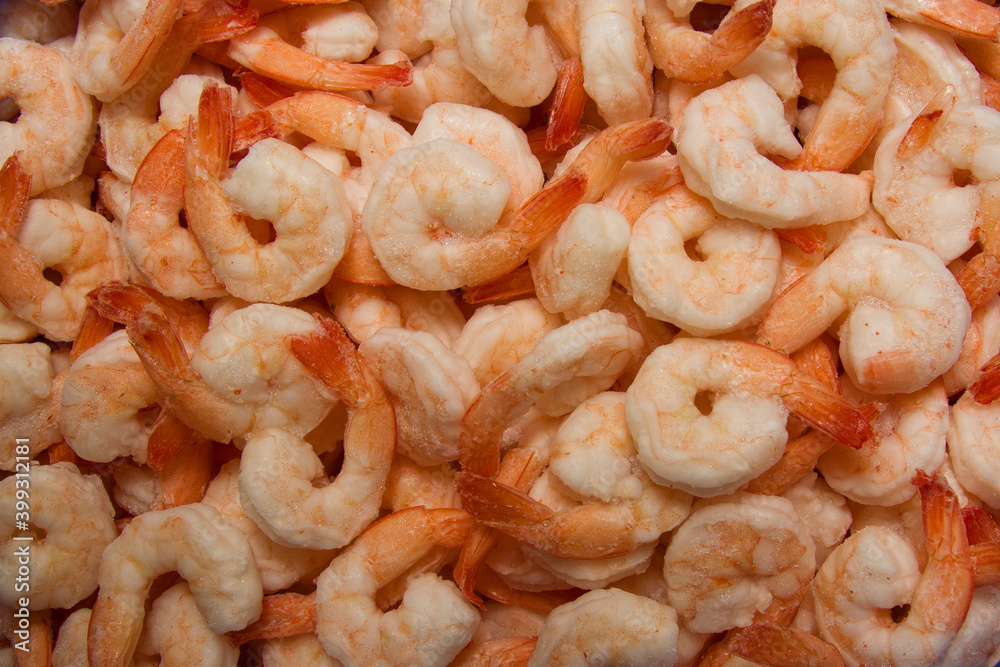Close-up of a heap of frozen peeled orange shrimp. Natural seafood background. Top view, vertical format. Close-up of a heap of frozen peeled orange shrimp. Natural seafood background. Top view, vertical format.