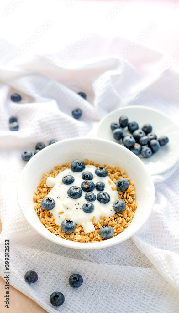 Delicious homemade muesli and blueberries served on a beige table with a white napkin, top view with space for text. Healthy breakfast Delicious homemade muesli and blueberries served on a beige table with a white napkin, top view with space for text. Healthy breakfast