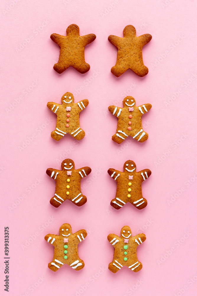 Smiling Christmas gingerbread men with happy faces on pink background