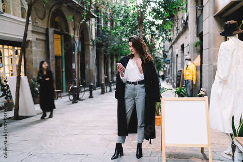 Stylish female using smartphone on street