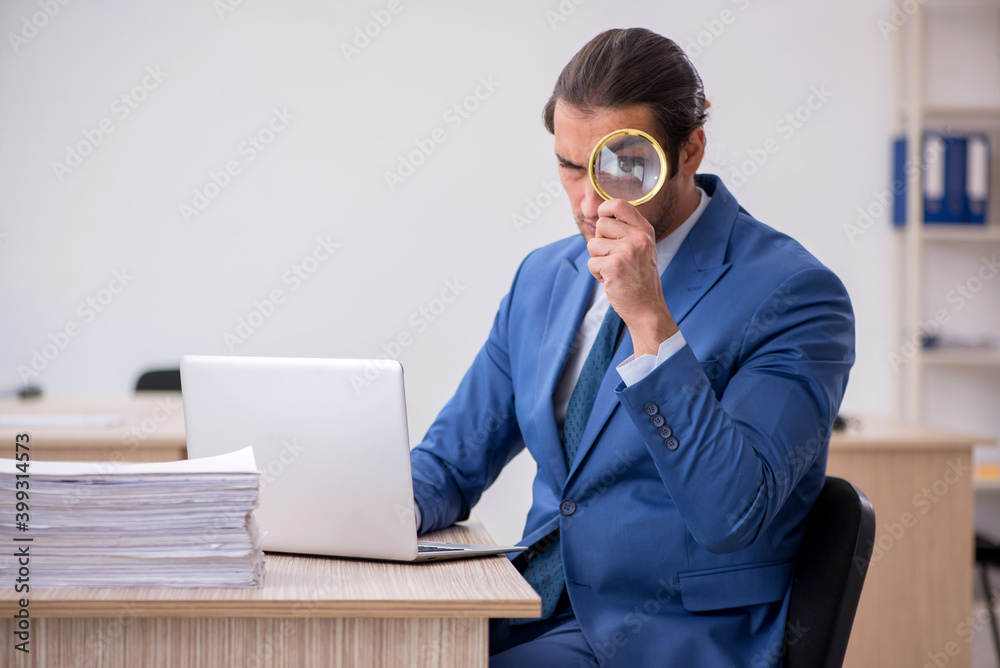 Young male employee and too much work in the office Young male employee and too much work in the office