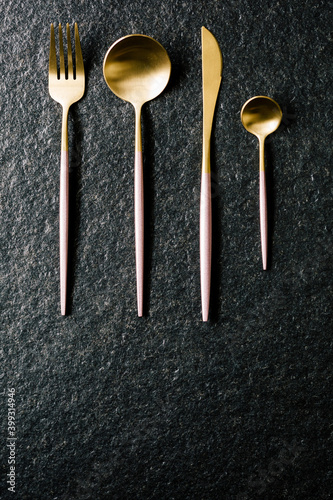 elegant pink and gold cutlery set. Top and flat view. copy space.black background © Joseph Table