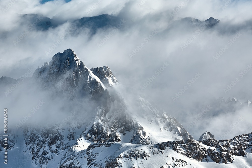 Winter high mountain landscape covered in clouds and snow