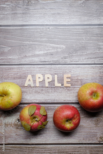 Red tasty apples fruits on a wooden table with apple word written on wood