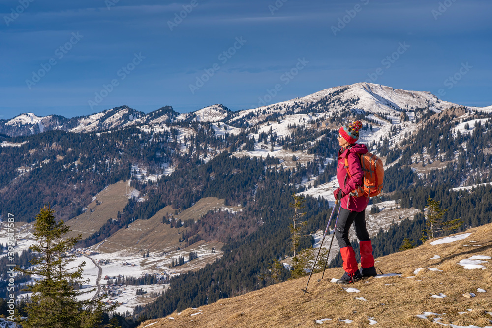 Obraz premium nice and active senior woman snowshoeing in deep powder snow in the Allgau alps, Bavaria, Germany