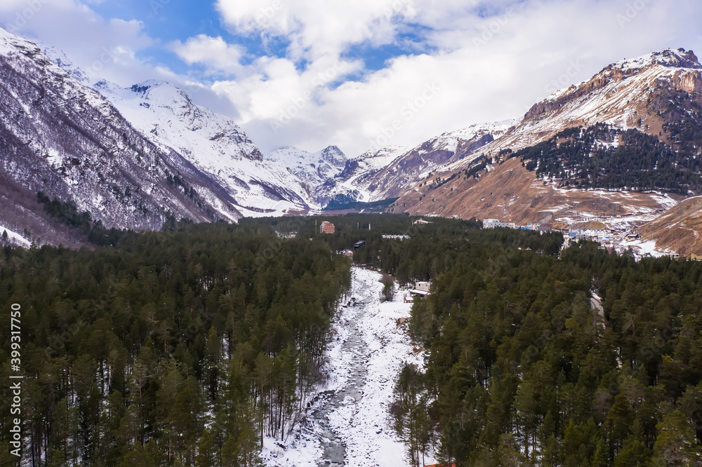 Aerial view of the winter mountain river in the Cheget valley
