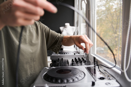 Dj standing near the window and preparing to the work