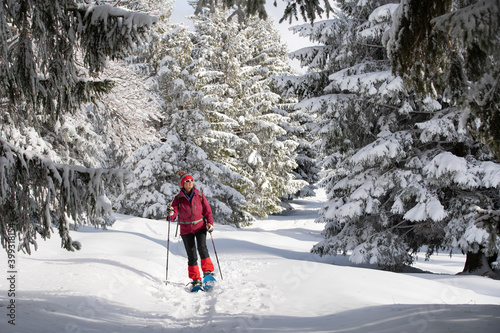 nice and active senior woman snowshoeing in deep powder snow in the Allgau alps, Bavaria, Germany