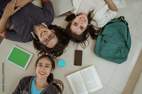 Portrait fun students lying down working in groups on the floor