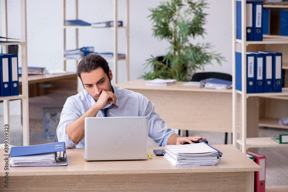 Young male bookkeeper working in the office Young male bookkeeper working in the office