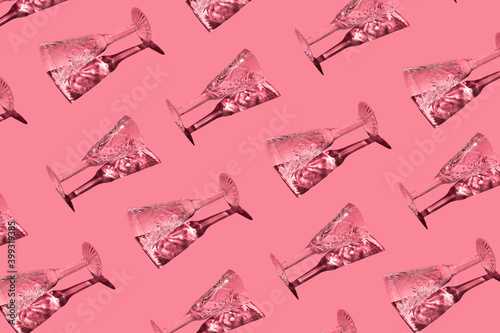 A pattern of champagne glasses on a pink background. Christmas seamless pattern	