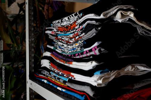 selective focus photo of t-shirts with bright prints, printed by silkscreen. serigraphy production. printing images on t-shirts in a design studio.