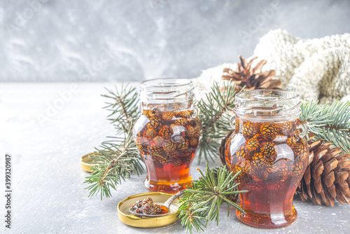 Traditional Siberian and Ukrainian sweet dessert jam. Homemade Pine Cone Jam in small cute jars, with pine cones and branches