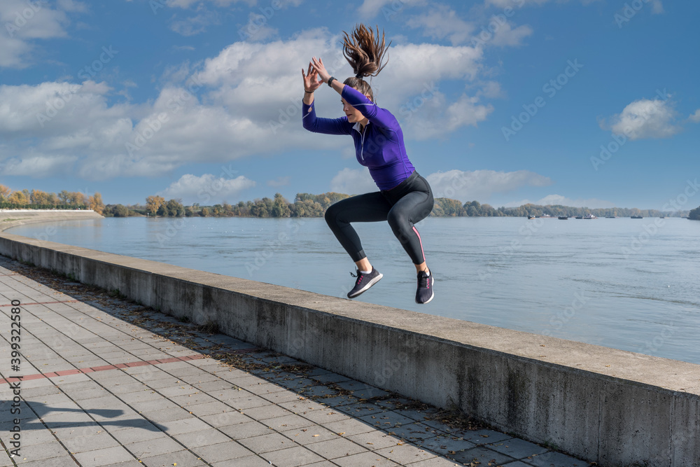 Young active sexy strong fit woman jump with high knees as outdoor hardcore cardio cross workout training with motion blur Young active sexy strong fit woman jump with high knees as outdoor hardcore cardio cross workout training with motion blur