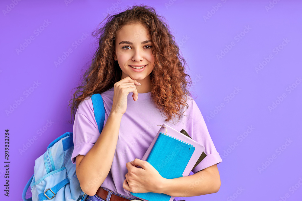 intelligent caucasian student girl enjoying education, she holds books in hands, posing at camera isolated intelligent caucasian student girl enjoying education, she holds books in hands, posing at camera isolated