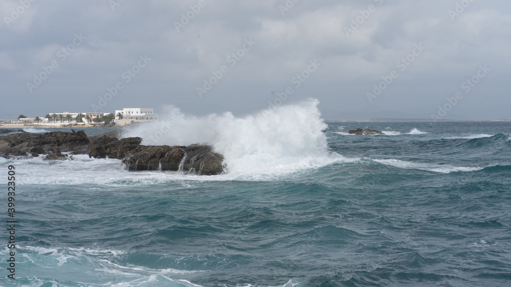 waves crashing against the rocks on a windy day waves crashing against the rocks on a windy day