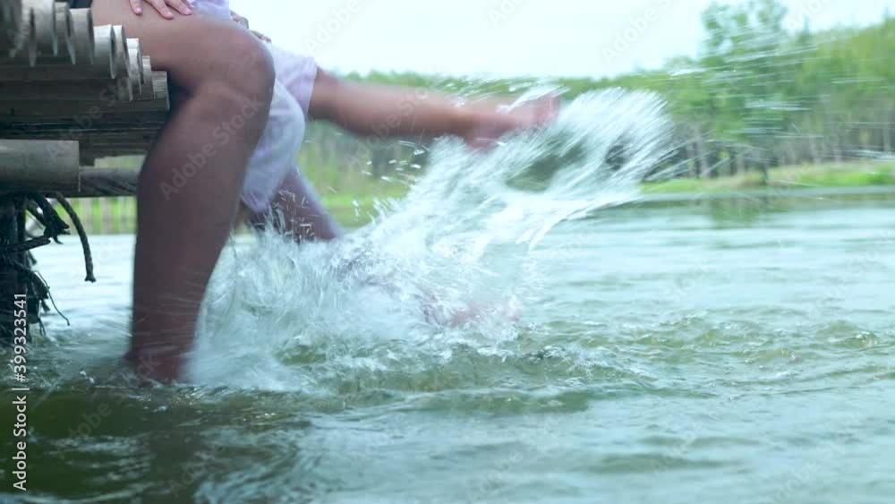 Traveler having fun with legs dangling and hitting at lake Traveler having fun with legs dangling and hitting at lake