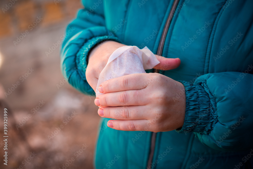 Girl wipes her hands with a napkin outside in frost