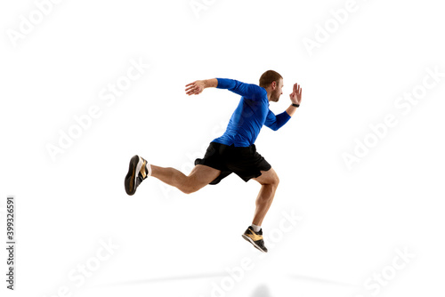 Achievement. Caucasian professional jogger, runner training isolated on white studio background. Muscular, sportive man, emotional. Concept of action, motion, youth, healthy lifestyle. Copyspace for