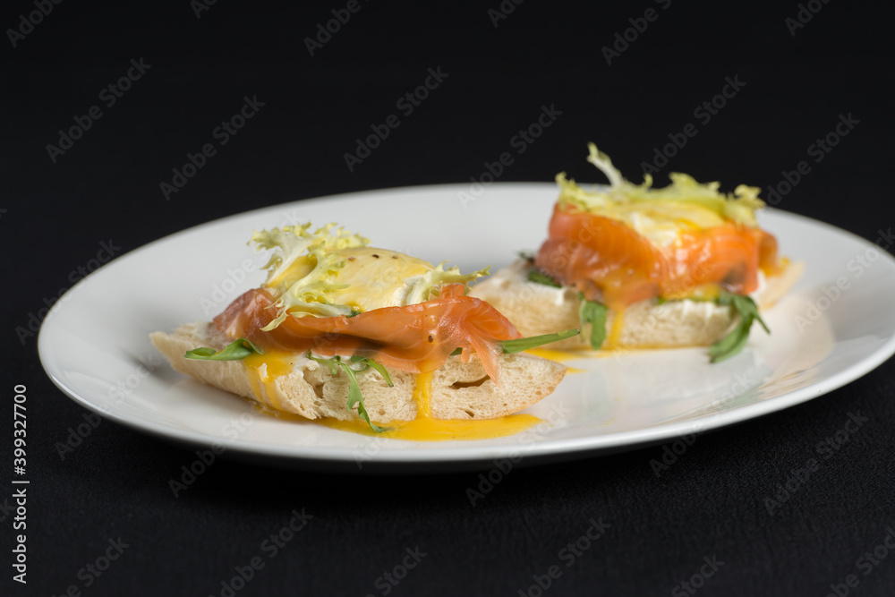 A delicious eggs benedict with lightly salted salmon and sauce. A delicious eggs benedict with lightly salted salmon and sauce.