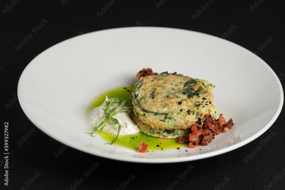 Zucchini pancakes served with sun-dried tomatoes and cream cheese
