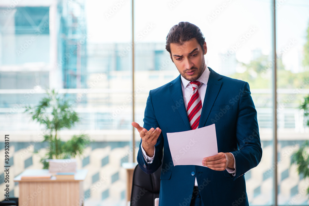 Young handsome employee working in the office Young handsome employee working in the office