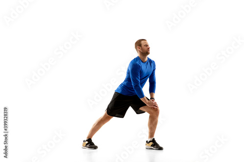 Prepares. Caucasian professional jogger, runner training isolated on white studio background. Muscular, sportive man, emotional. Concept of action, motion, youth, healthy lifestyle. Copyspace for ad.