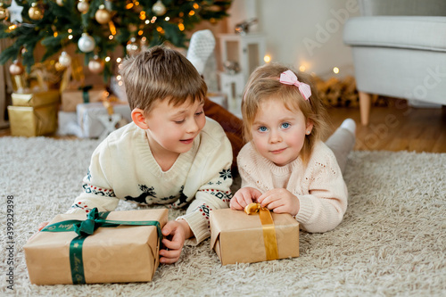 Christmas. Happy kids open gifts near the Christmas tree. Holidays.