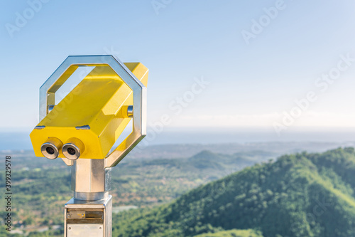 Yellow metallic binoculars with a blurred nature background