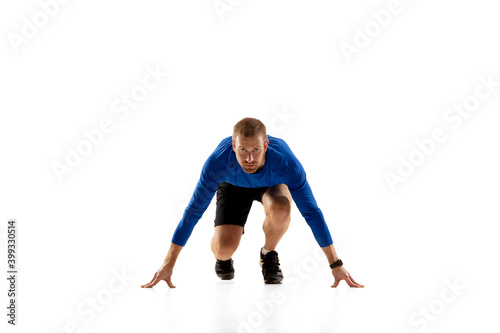 Start. Caucasian professional jogger, runner training isolated on white studio background. Muscular, sportive man, emotional. Concept of action, motion, youth, healthy lifestyle. Copyspace for ad.